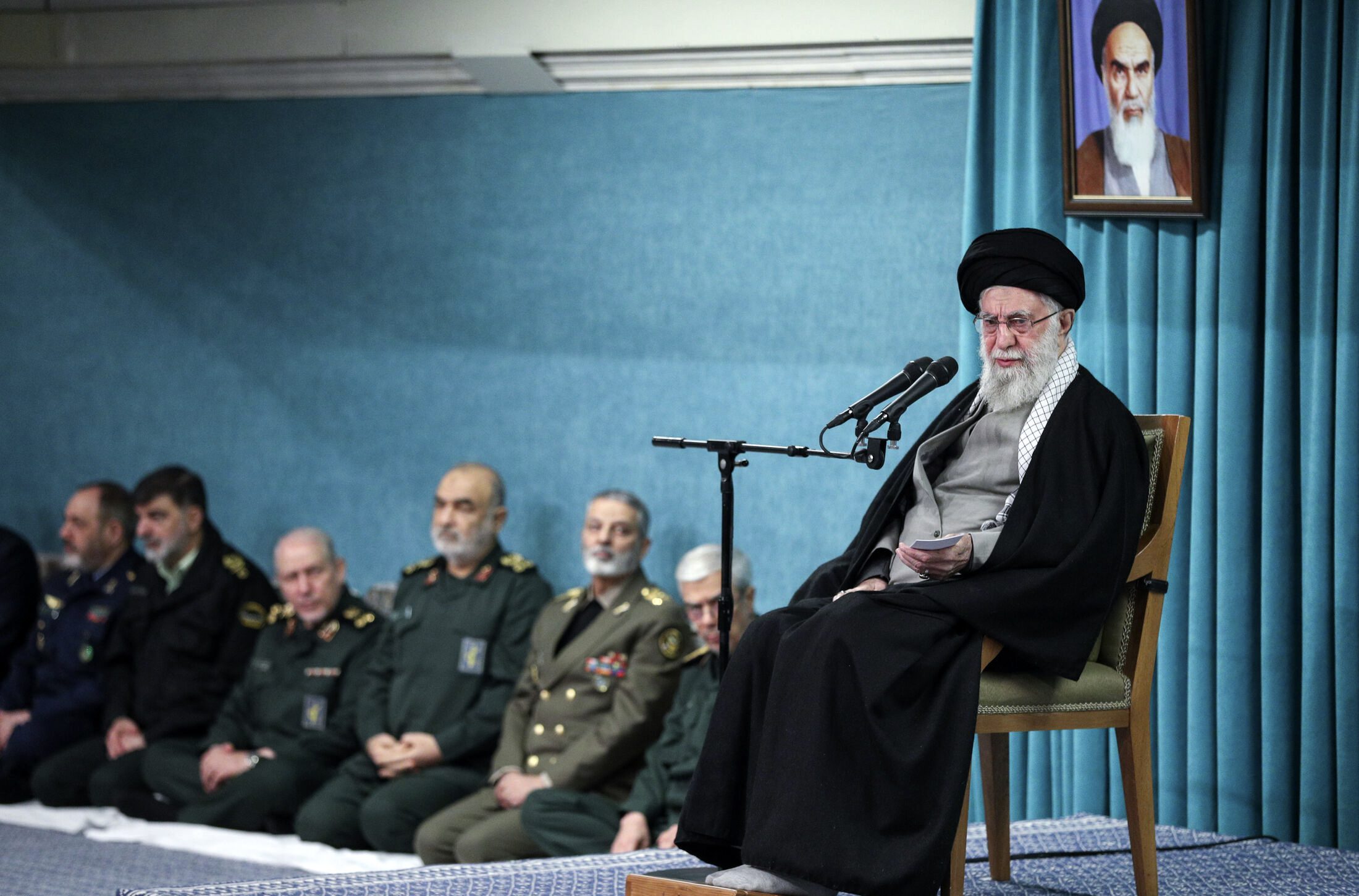 Supreme Leader Ayatollah Ali Khamenei speaks under a portrait of the late revolutionary founder Ayatollah Khomeini, as armed forces commander listen, at rear, in a ceremony meeting a group of officials, in Tehran, Iran, March 8. (Office of the Iranian Supreme Leader via AP)