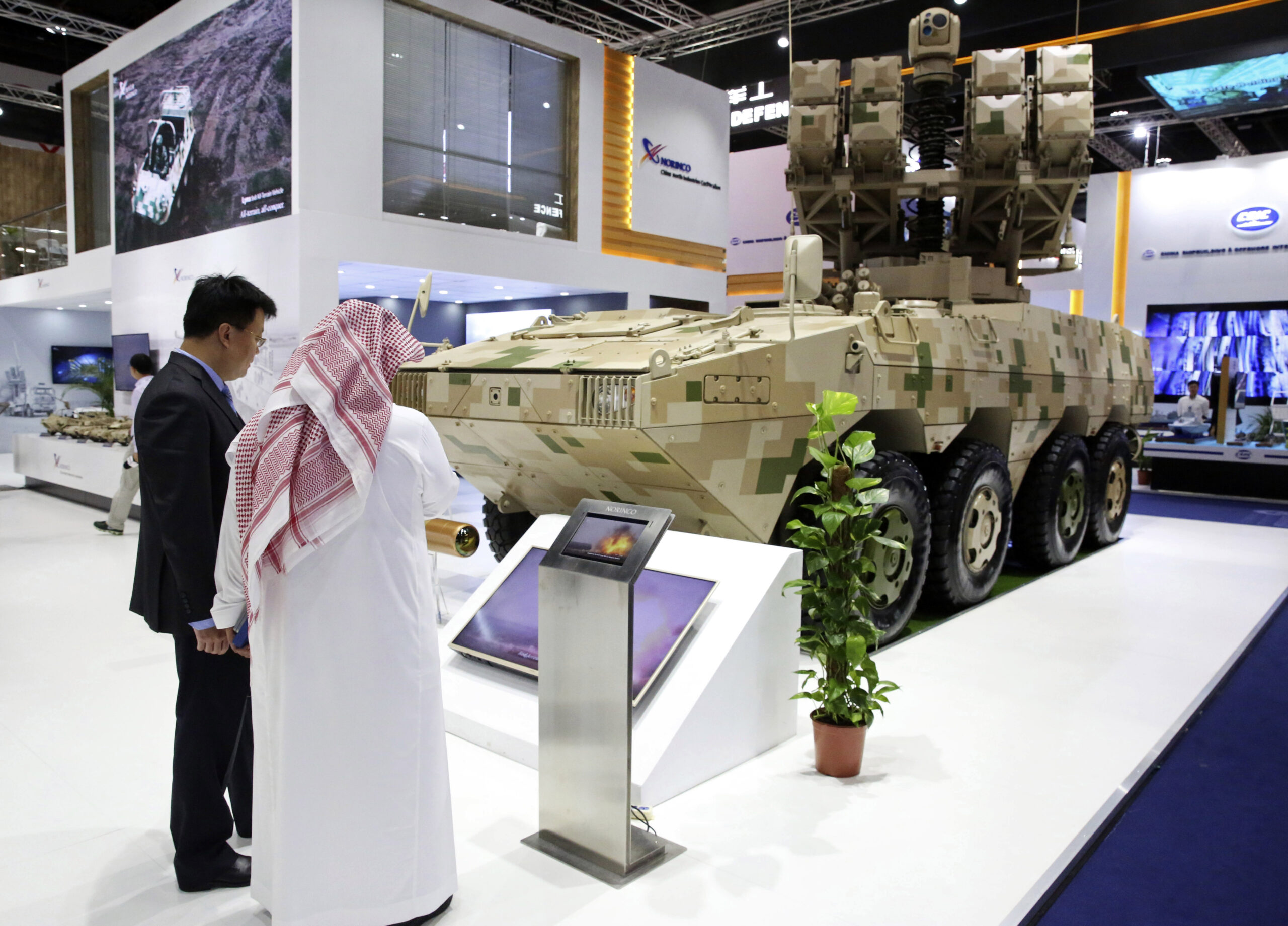 A Chinese salesman speaks to a visitor about a mobile missile launcher made by Norinco at the International Defense Exhibition and Conference in Abu Dhabi, United Arab Emirates, Feb. 17. (AP Photo/Jon Gambrell)