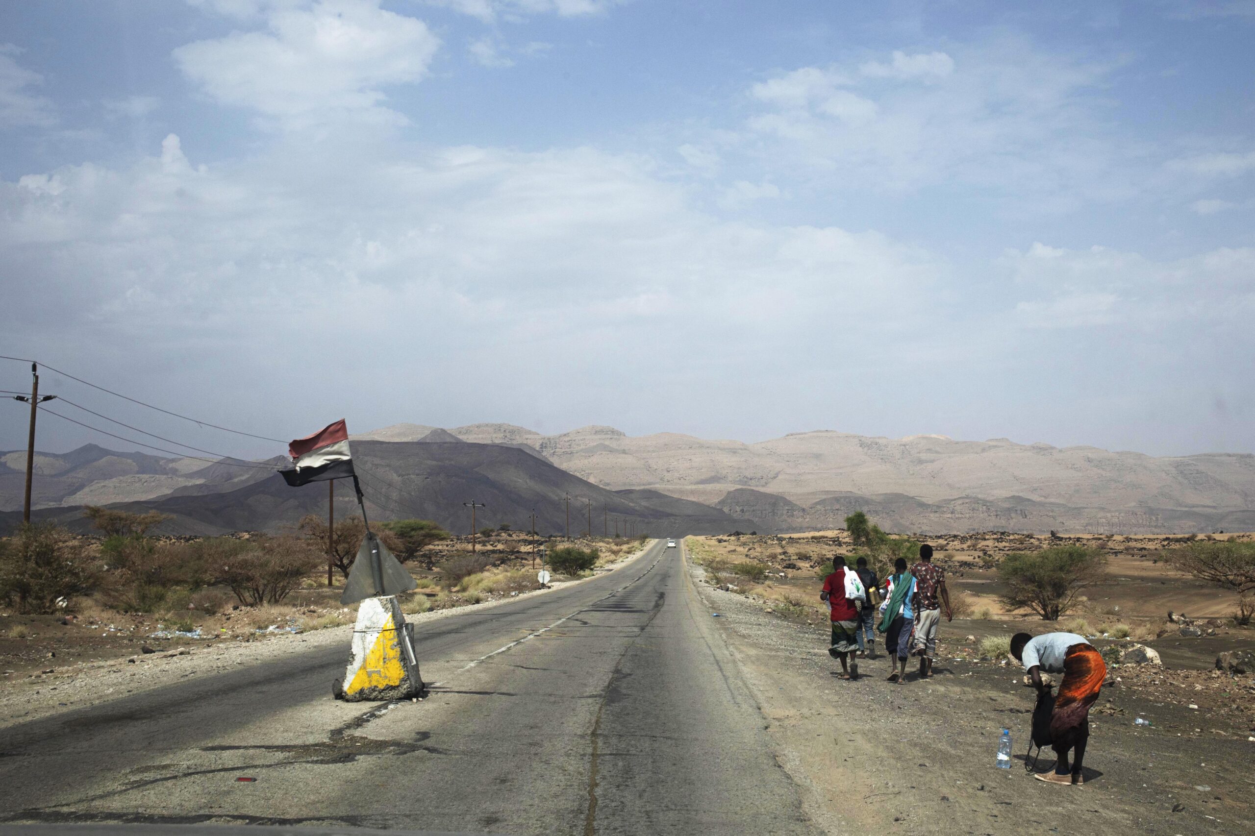 Migrants walk past a checkpoint crossing from Marib to Jawf, in Yemen, July 30, 2019 . (AP Photo/Nariman El-Mofty)
