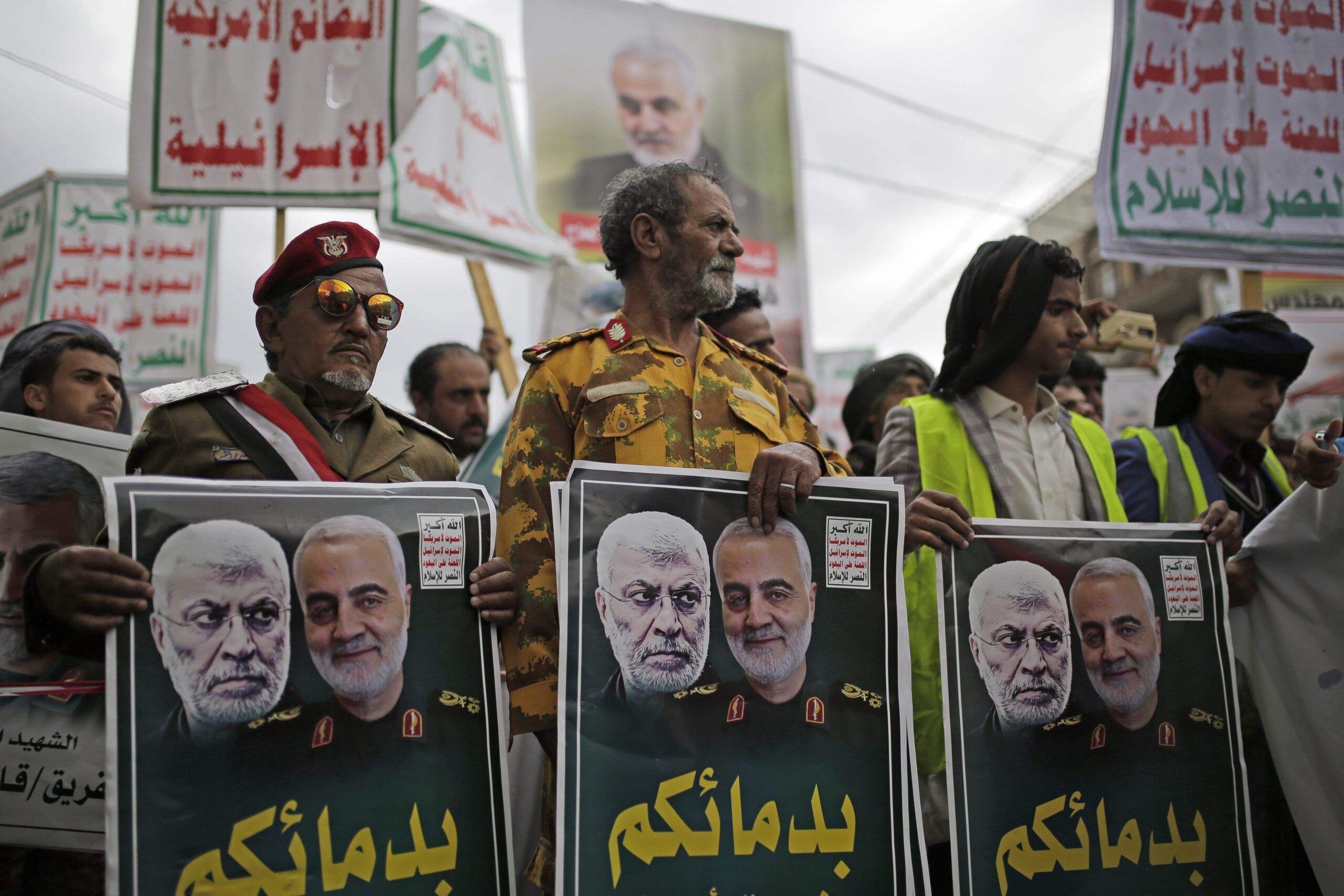 Yemeni Houthis hold posters of Iraqi militia commander Abu Mahdi al-Muhandis and Iranian military commander Qassim Sileimani during a protest against a U.S. airstrike in Iraq that killed them both, in Sanaa, Yemen, Jan. 6. (AP Photo/Hani Mohammed)
