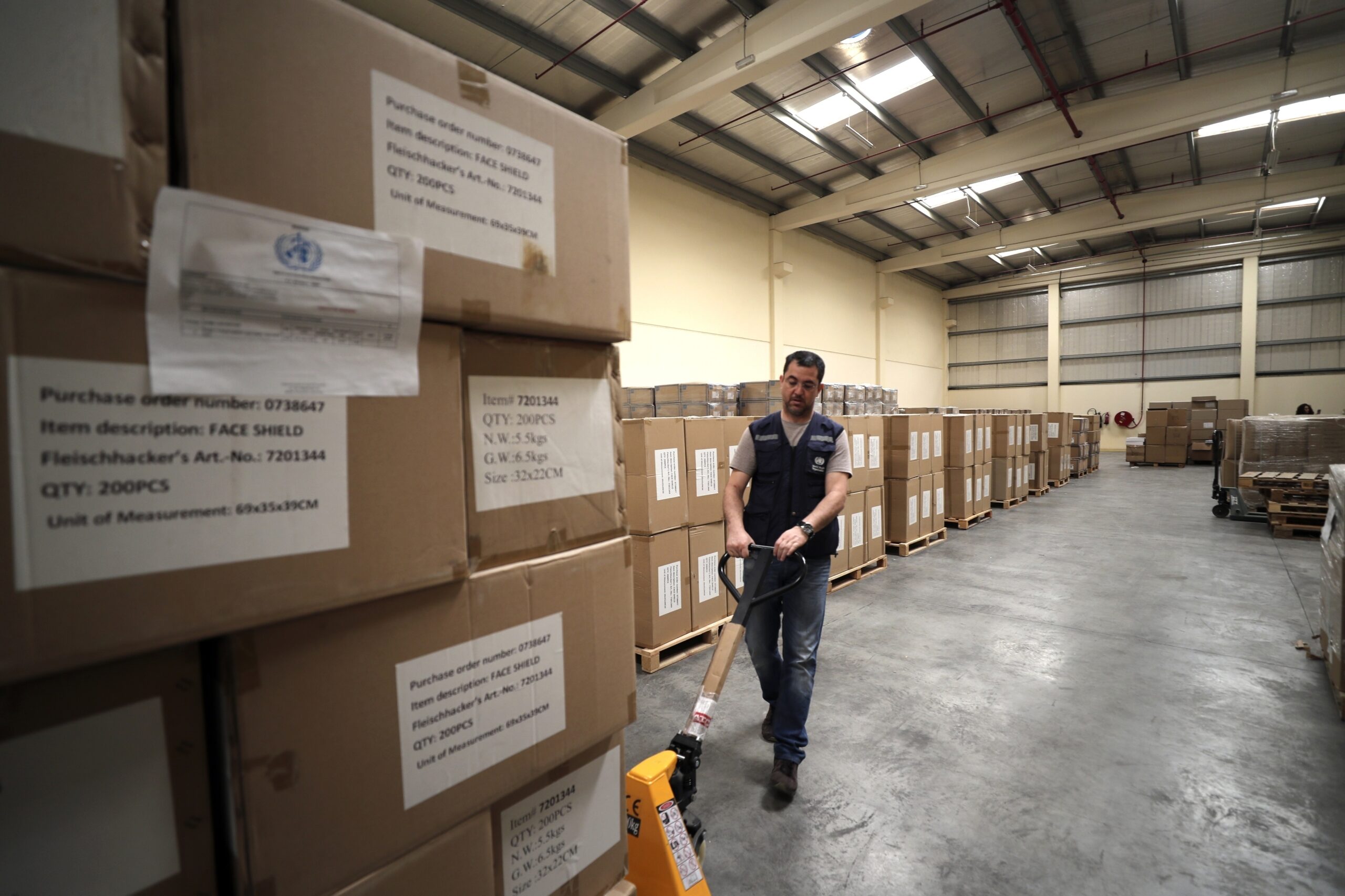 A worker pulls a cart of coronavirus aid items being prepared for shipment at a World Health Organization facility in Dubai, United Arab Emirates. March 5. (AP Photo/Kamran Jebreili)