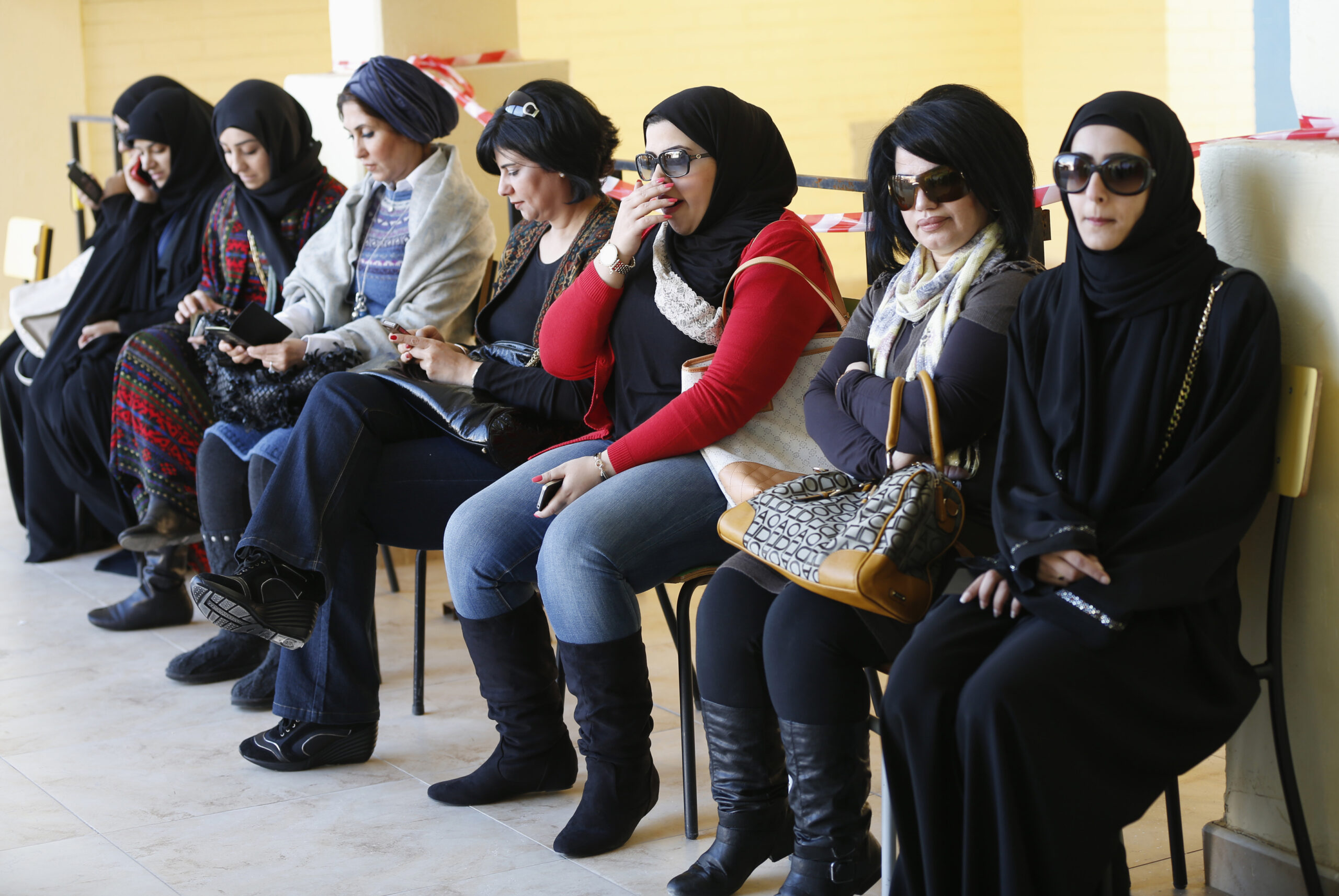 Women sit as they wait to cast their votes during parliamentary elections at a polling station in Kuwait City, December 1, 2012. (REUTERS/Jamal Saidi)