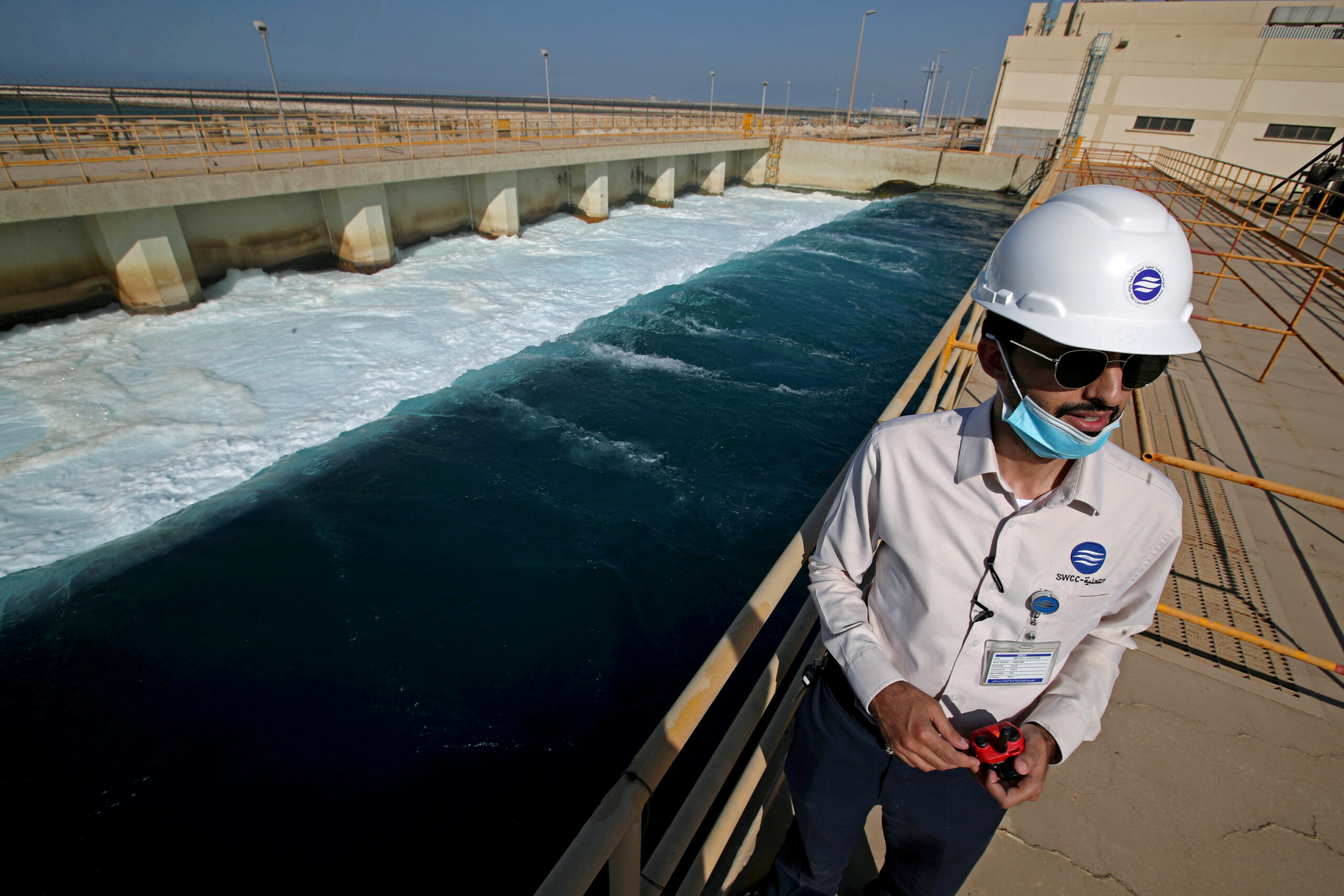 An employee stands next to a waste water collection pool at the Saline Water Conversion Corporation's Ras Al-Khair Power and Desalination Plant, the world's largest desalination plant using modern hybrid desalination technology, Ras Al-Khair, Saudi Arabia, October 8, 2020. (REUTERS/Hamad I Mohammed)