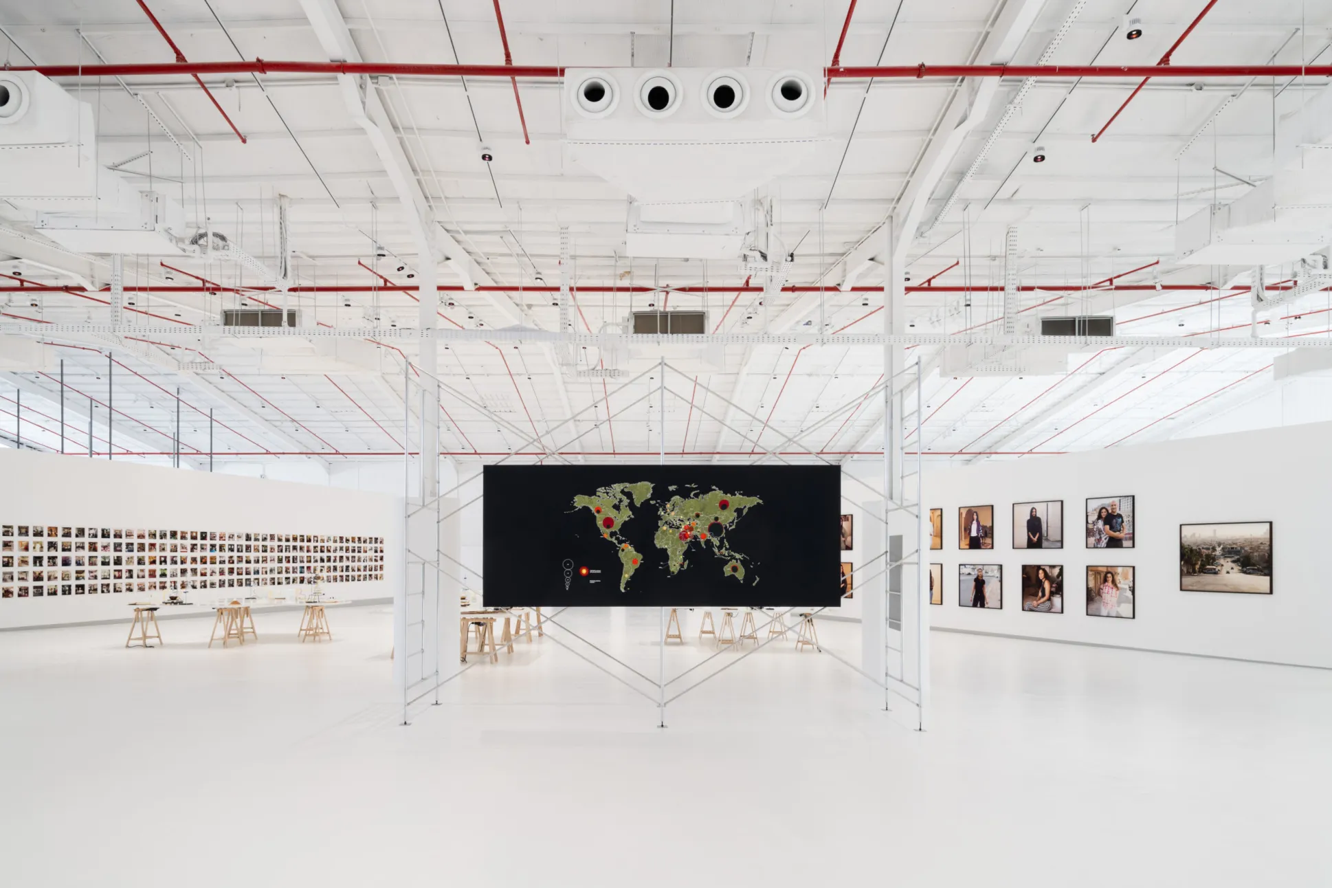 "After Rain," Diriyah Contemporary Art Biennale 2024, installation view: Tiffany Chung, "Energy Policy vol.166: potential CO2 emissions until 2050 by key fossil fuel and coal extraction projects [each>1 Gt] worldwide" (2023), center; Simryn Gill, "Dalam" (2001), left background, on wall; Ade Darmawan, "Tuban"(2019), left background, on floor; Christine Fenzl, "Women of Riyadh" (2023), right background, on wall. Photo by Marco Cappelletti, courtesy of Diriyah Biennale Foundation.